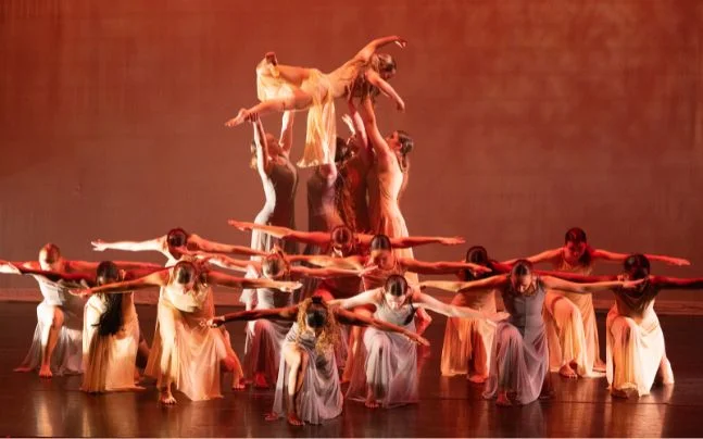 Dancers in pose with dancer being held up in air