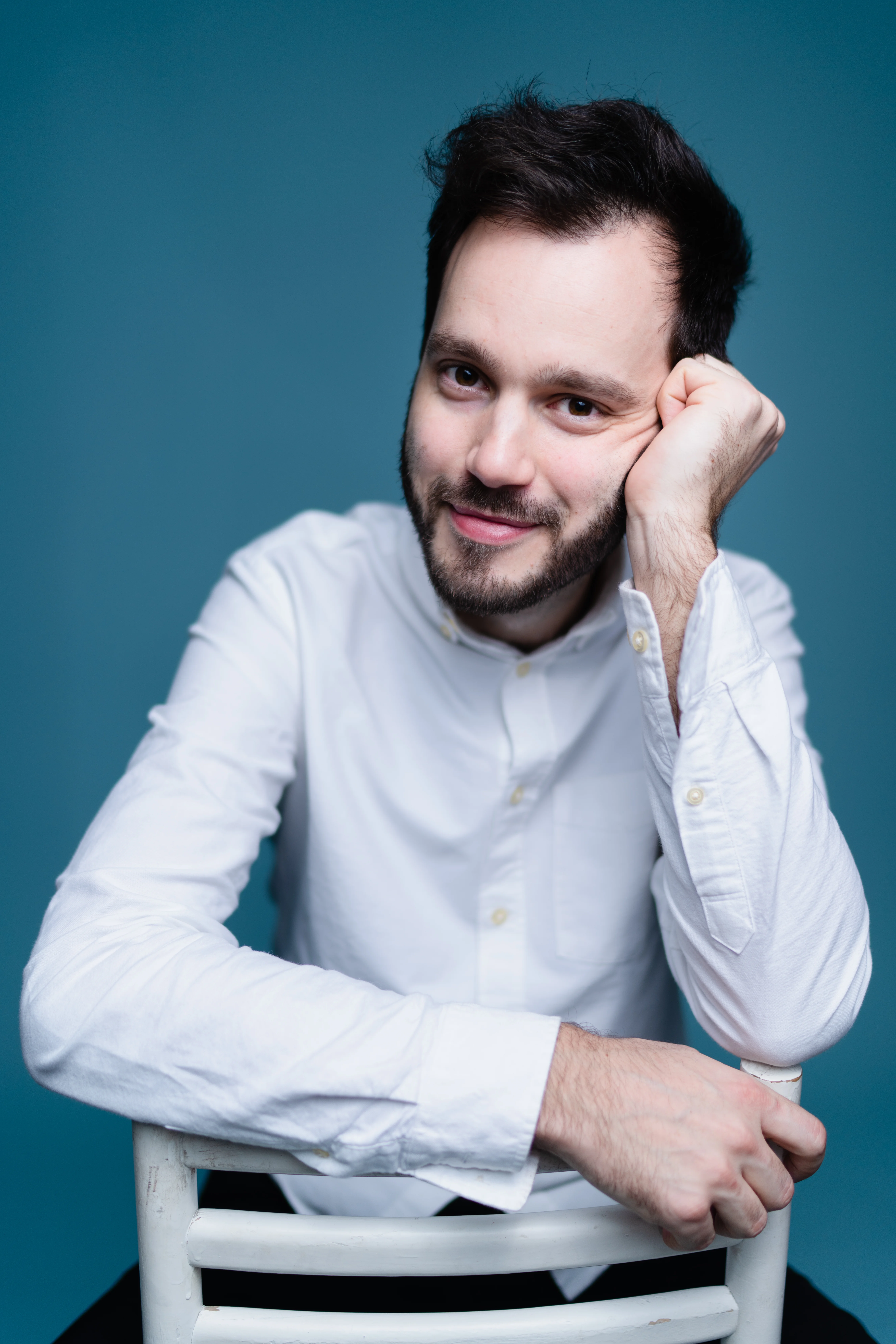 Antonii Baryshevskyi sitting in backwards on chair posing for camera.