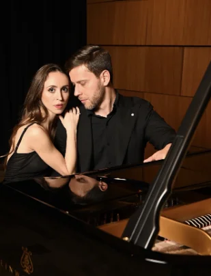 Skykar and Vladimir embrace at piano.