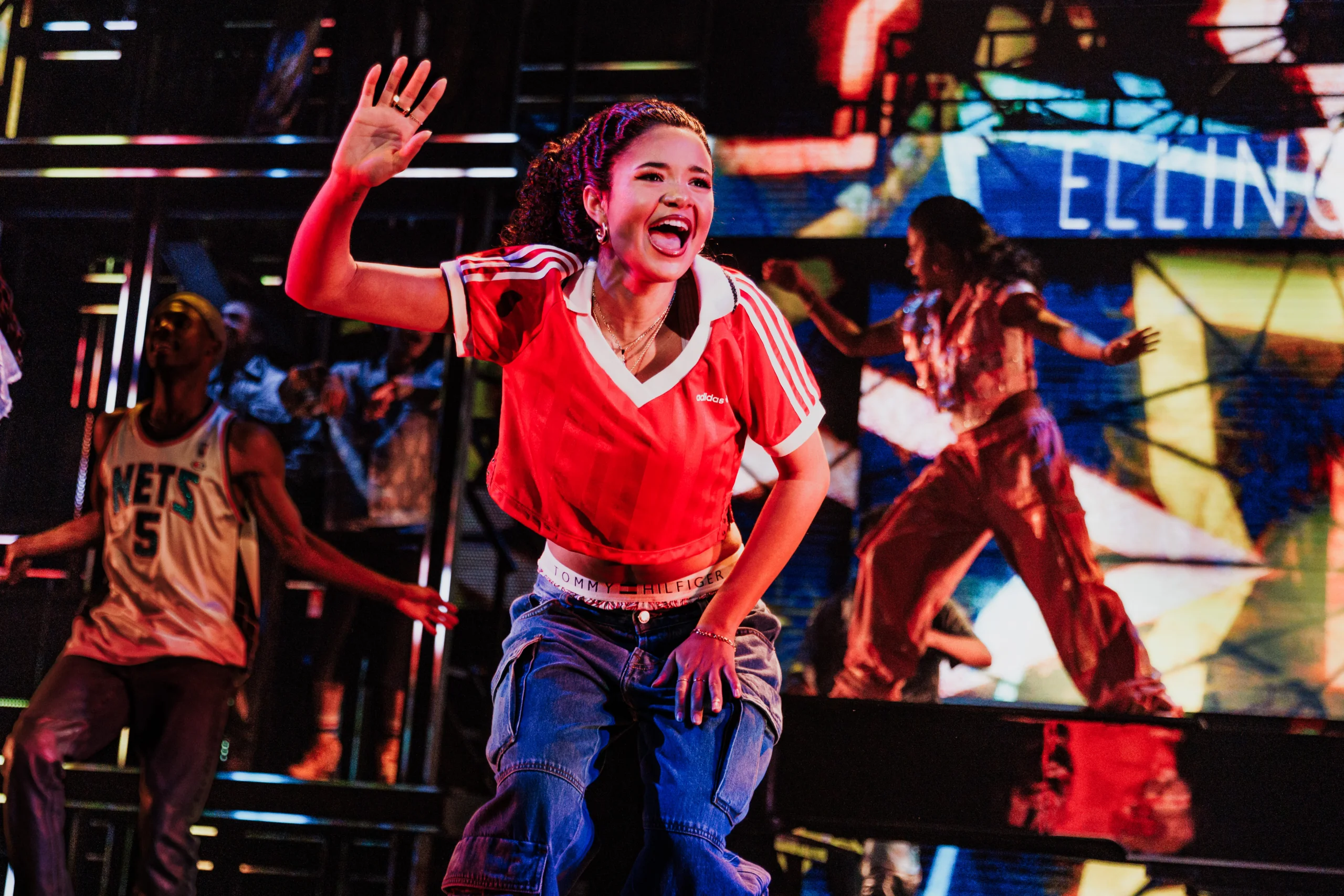 Maya Drake as Ali dancing with background dancers.