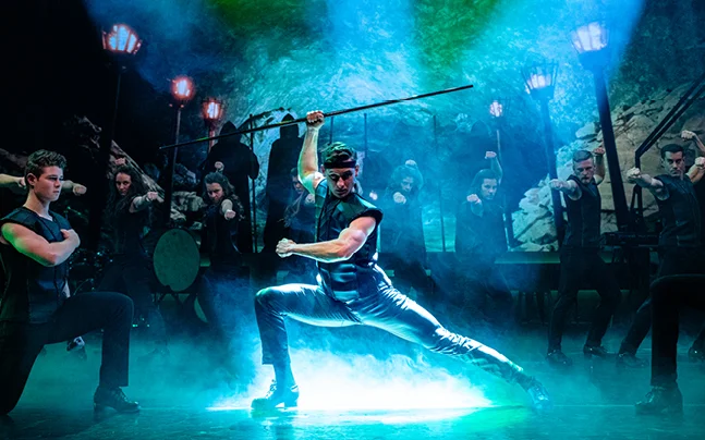 Male lead dancer and ensemble perform a dramatic Irish dance scene in Celtic Throne II, combining athletic choreography and Celtic storytelling.