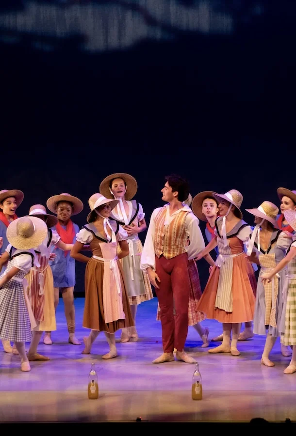 Ballet students gathering in a circle.