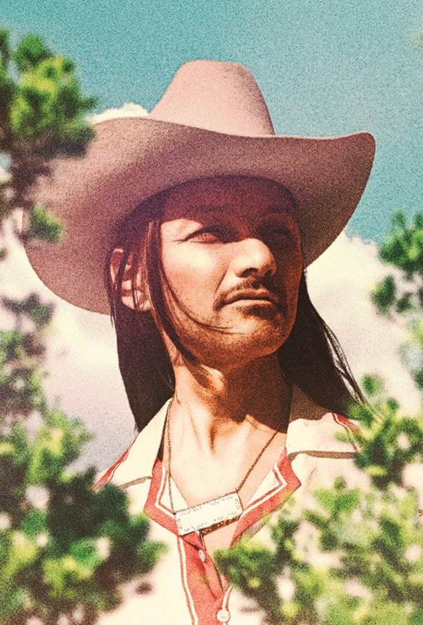 Duane Betts headshot thru bushes.