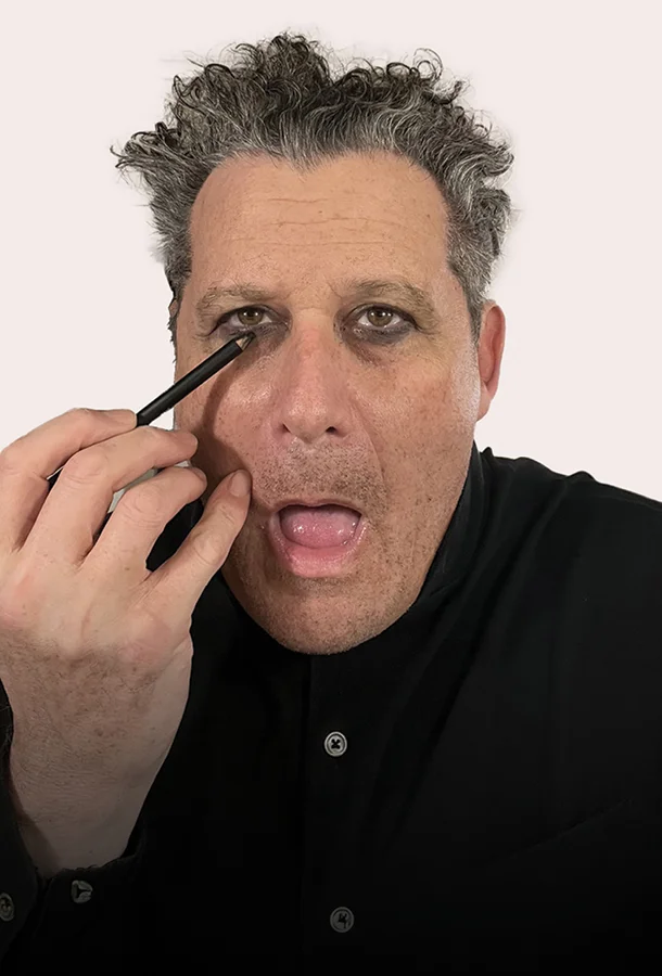 Isaac Mizrahi applying mascara to eyes.