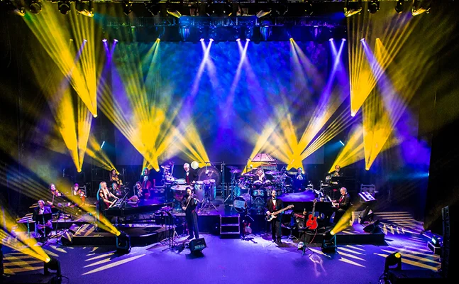 Full Mannheim Steamroller band perform on stage.