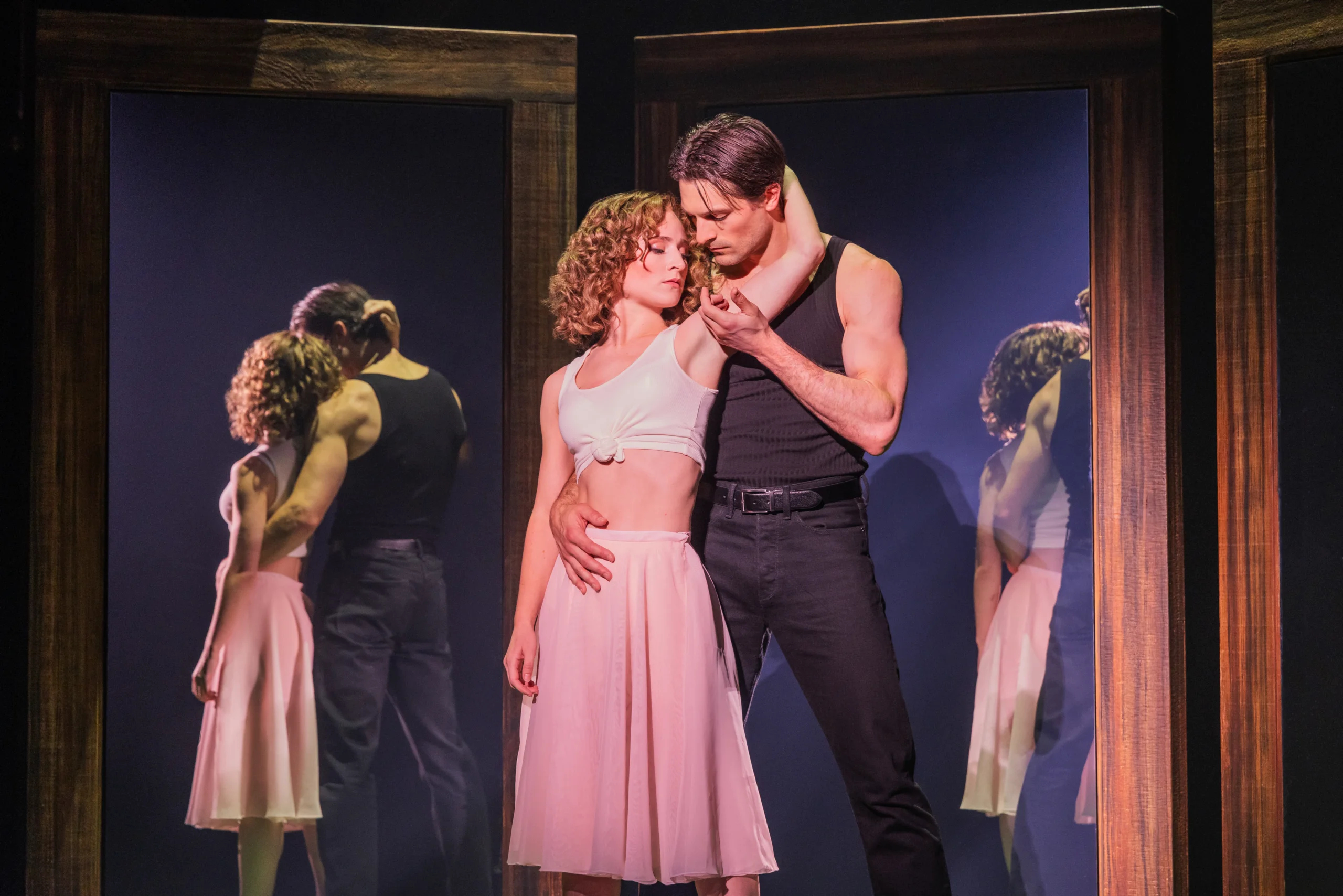Dirty Dancing: The Musical stage production featuring performers in a dramatic dance sequence on a forest-inspired set.
