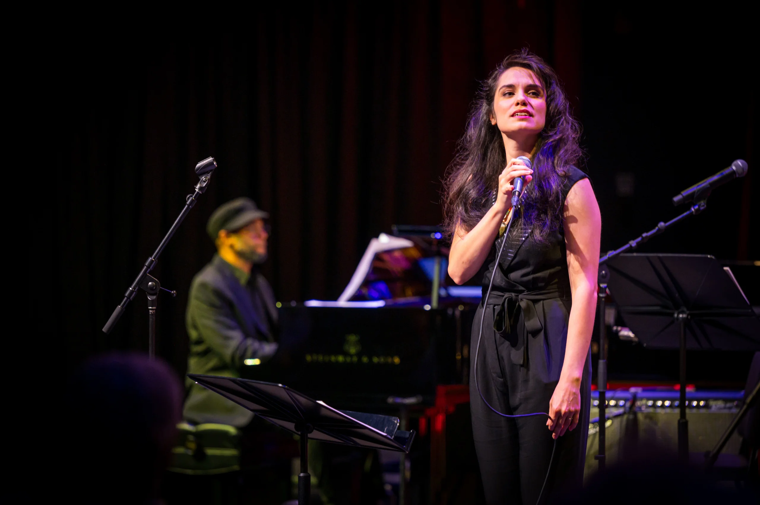 Julia Keefe sings in front of piano player.