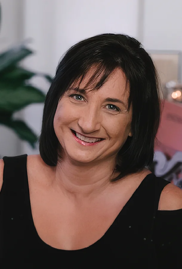 Professional portrait of author and educator Janda Taylor wearing a black top and smiling in an indoor setting. The image is used for literary arts and educational programming.