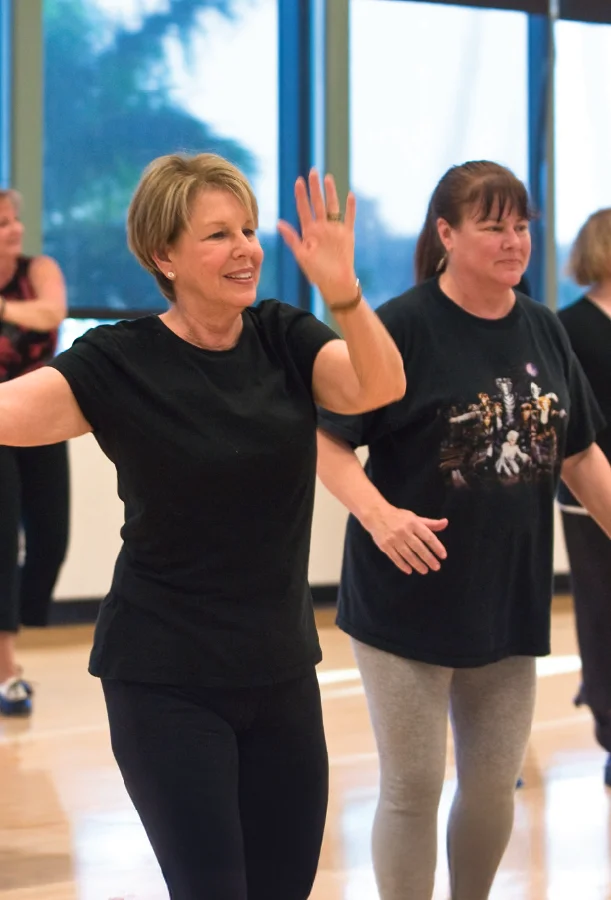 Participants taking part in a dance and movement class in a studio setting.