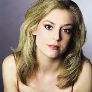 Studio portrait of Lori Ramirez wearing a red spaghetti strap top, photographed against a gradient gray background.