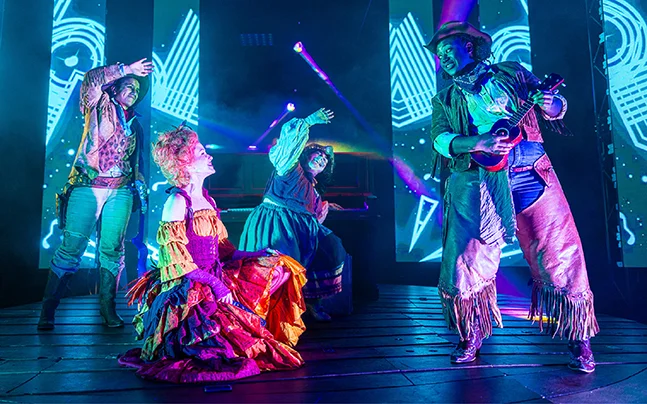 Performers in colorful costumes on stage during Musicians of Bremen Live! family theater production.