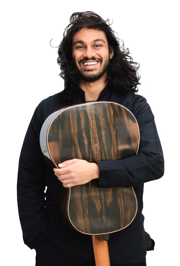 Classical guitarist Samrat Majumder holding an acoustic guitar in a studio portrait.
