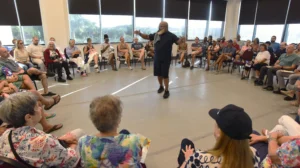 man in circle of people speaking to audience.