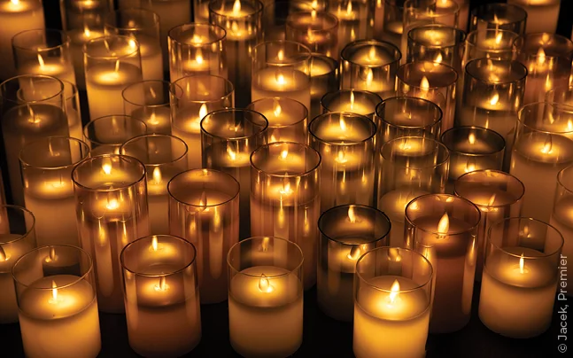 Rows of glowing candles in glass holders creating a warm concert atmosphere.