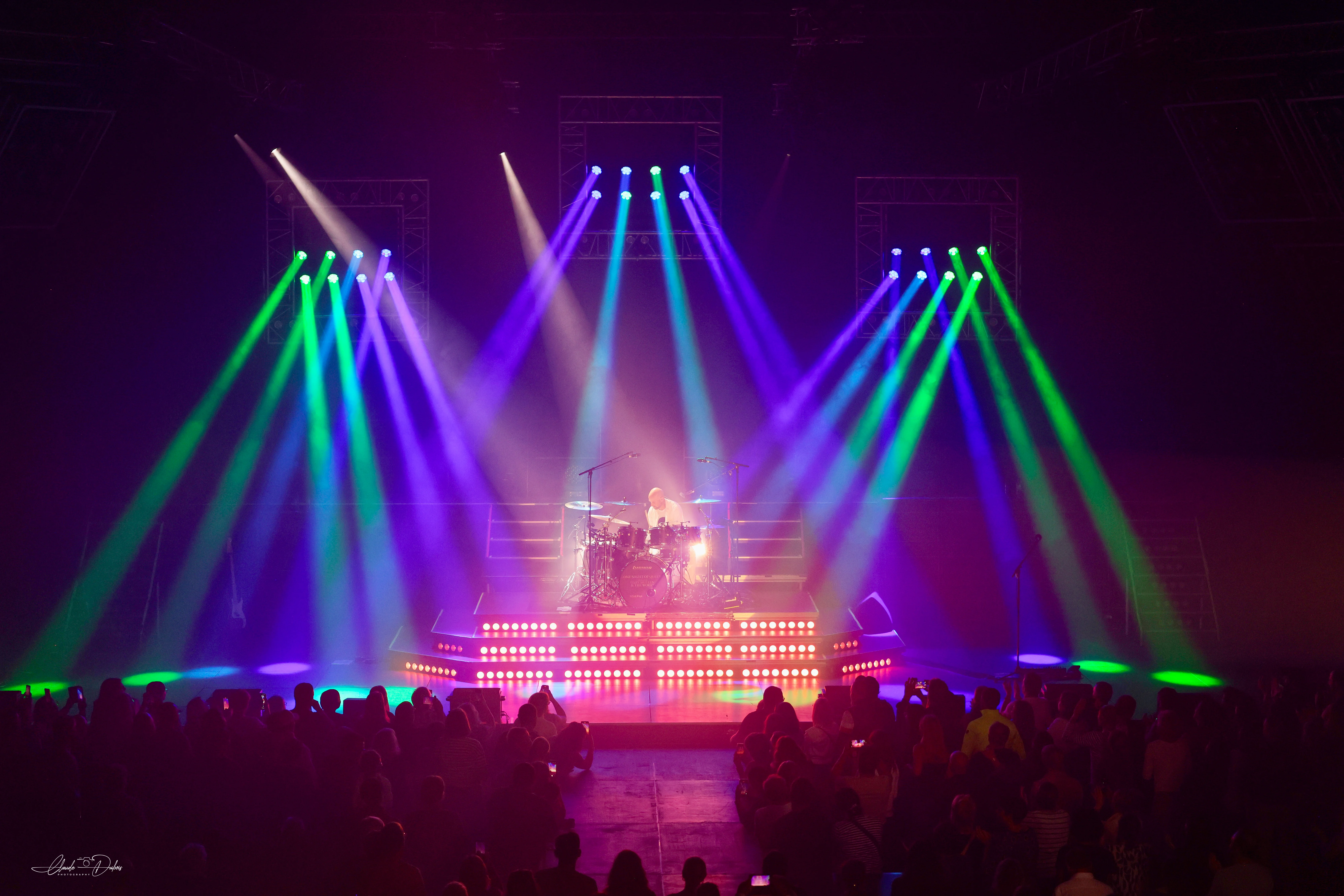 Dramatic theatrical lighting with band on stage.