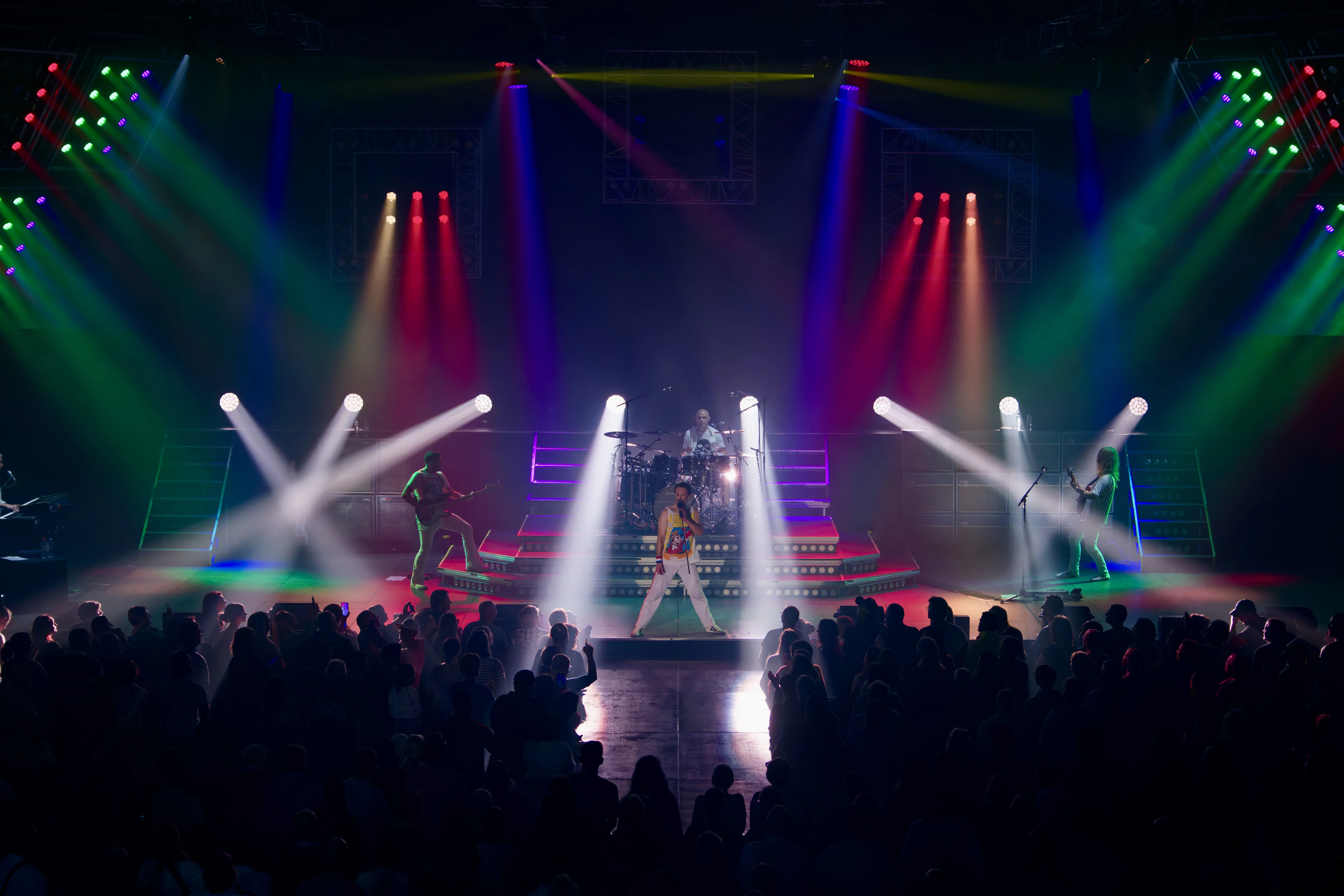 Dramatic theatrical lighting with band on stage.