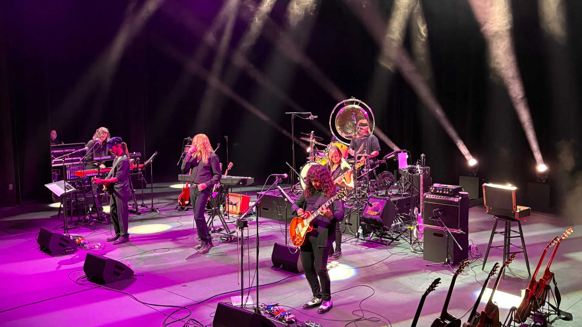 Dramatic theatrical lighting with band on stage.