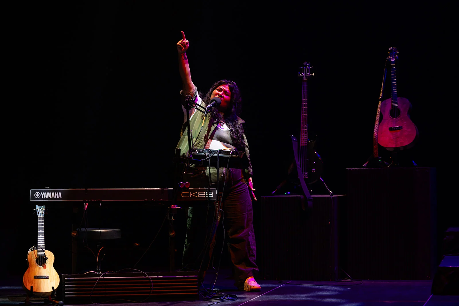 Female singing and pointing to the sky.